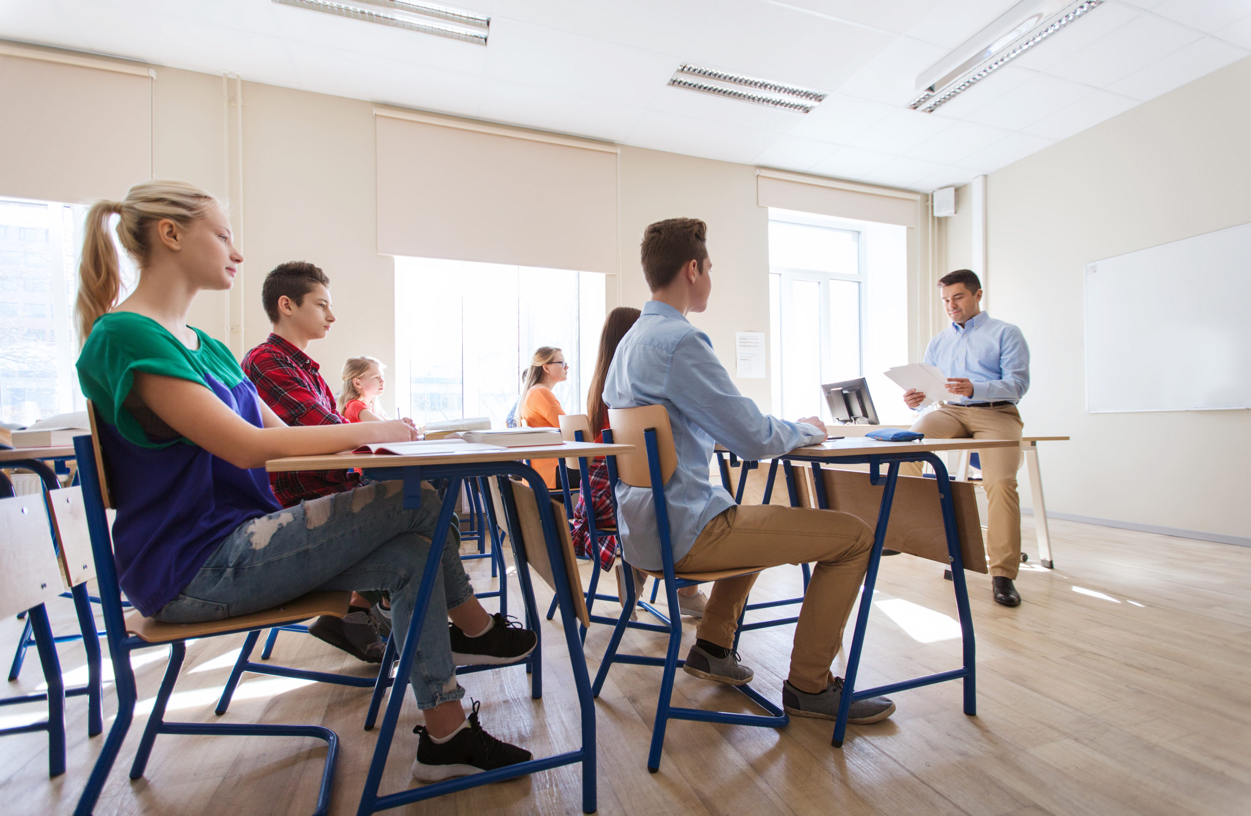 group of students and teacher with papers or tests